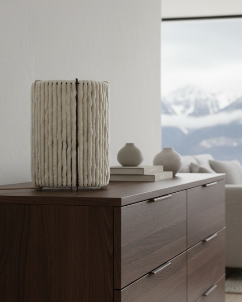 Lampe cylindre Nukumori posée sur une commode en bois foncé